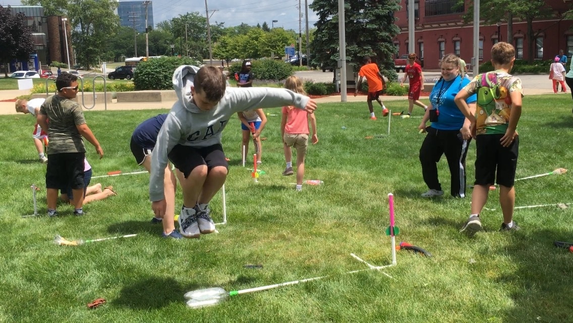Kids launching stomp rockets outside the library